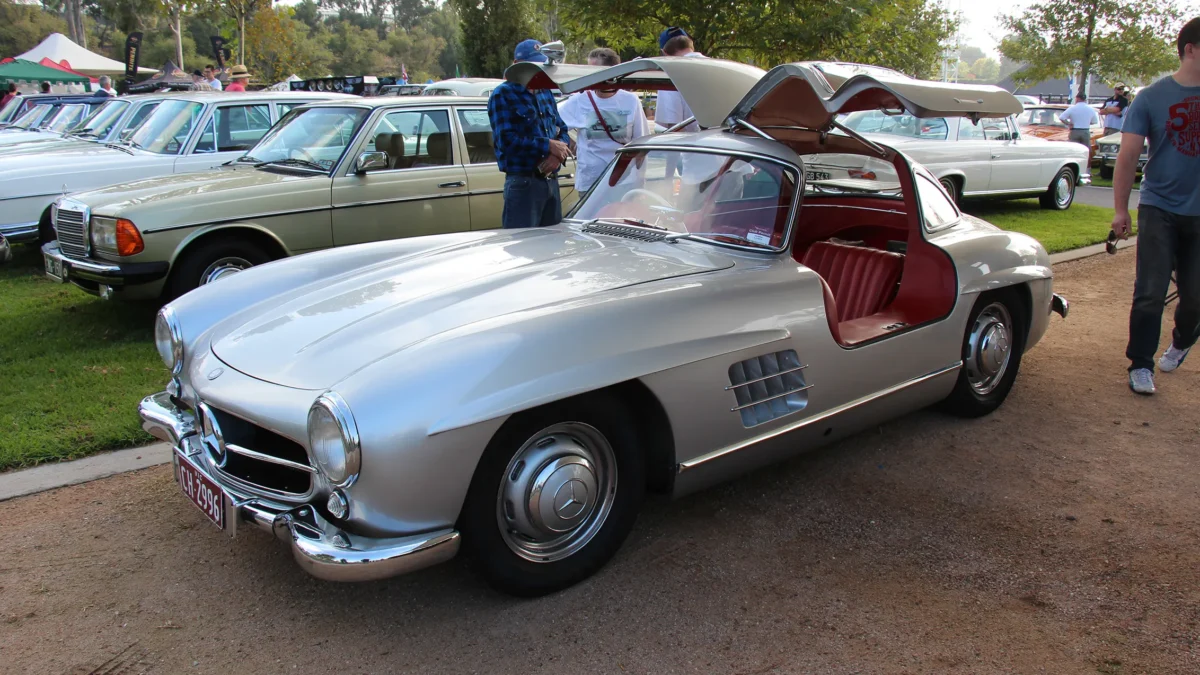 A 1954 Mercedes-Benz 300SL with its iconic gullwing doors open, showing the spaceframe chassis structure that necessitated the upward-opening design