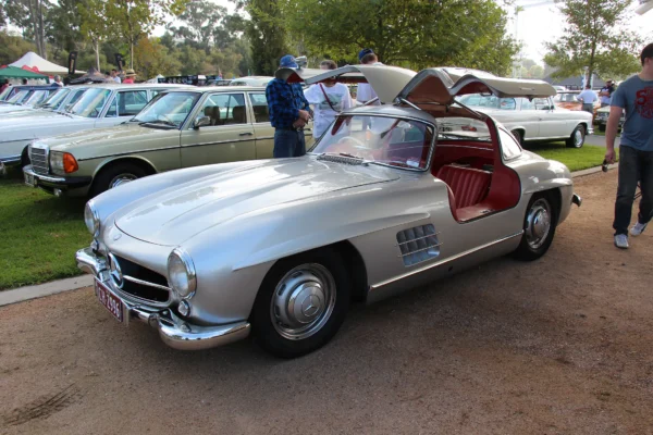 A 1954 Mercedes-Benz 300SL with its iconic gullwing doors open, showing the spaceframe chassis structure that necessitated the upward-opening design