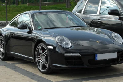 A Porsche 997.2 911 Carrera S coupe in Black with a manual gearbox parked on a clean tarmac surface, representing the last analogue generation of the iconic sports car.