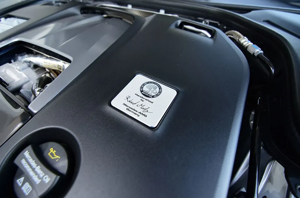 An AMG engine builder's signature plaque mounted on a hand-assembled AMG V8 engine at the Affalterbach facility in Germany