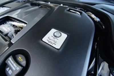 An AMG engine builder's signature plaque mounted on a hand-assembled AMG V8 engine at the Affalterbach facility in Germany