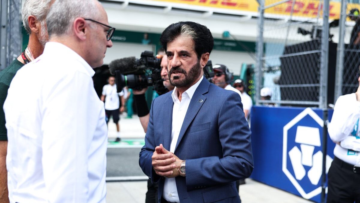 FIA president Mohammed Ben Sulayem speaking to media in the Miami Grand Prix paddock, with a 2026 Formula 1 power unit visible in the background.
