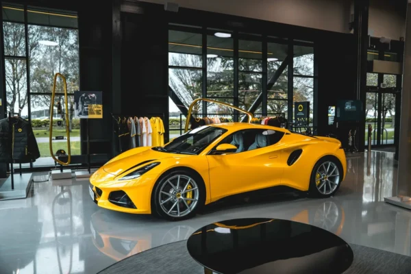 A Lotus Emira sports car parked at the Lotus factory in Hethel, Norfolk, representing the model that will switch to a new hybrid V6 powertrain alongside a revived Esprit V8 supercar.