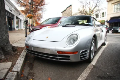 A silver Porsche 959 road car from 1986, the year it was unveiled, showing the wide-body aerodynamic design developed originally for Group B rally competition