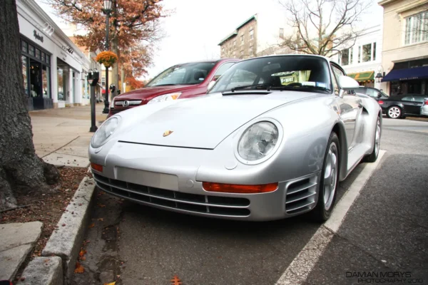 A silver Porsche 959 road car from 1986, the year it was unveiled, showing the wide-body aerodynamic design developed originally for Group B rally competition