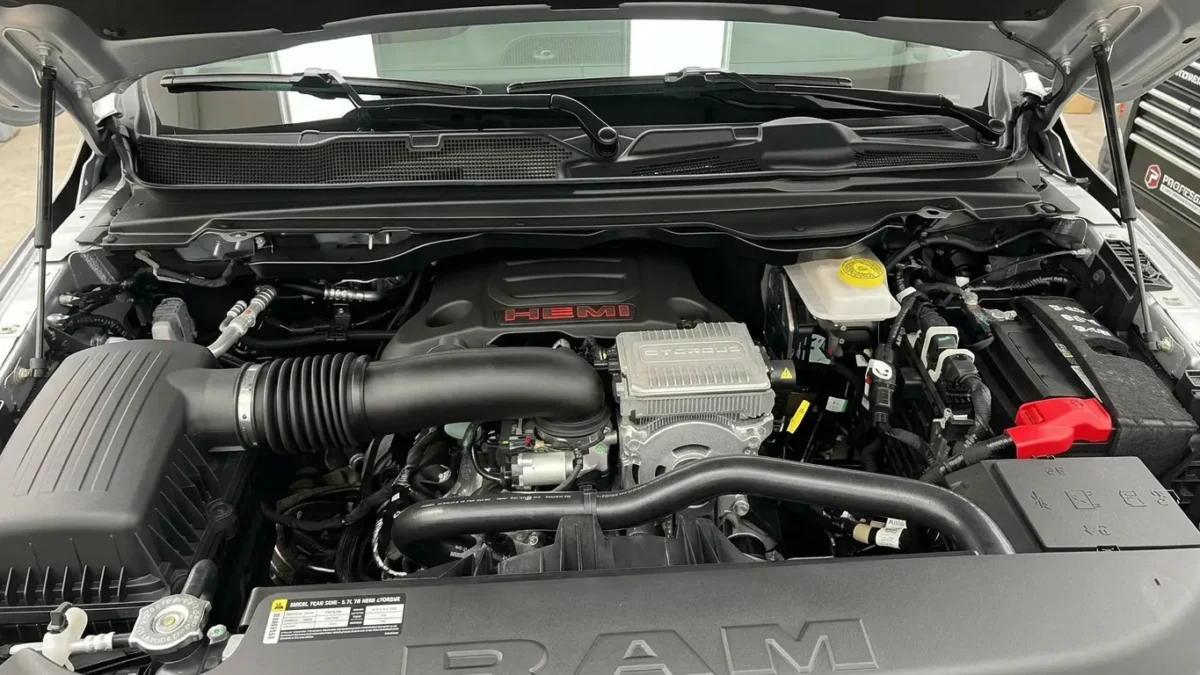 A 2026 Ram 1500 pickup truck displayed with a close-up of its Hemi V8 engine badge, illustrating the engine's return to Stellantis' core lineup after being discontinued in 2024.