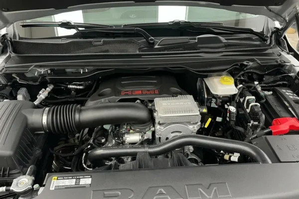 A 2026 Ram 1500 pickup truck displayed with a close-up of its Hemi V8 engine badge, illustrating the engine's return to Stellantis' core lineup after being discontinued in 2024.