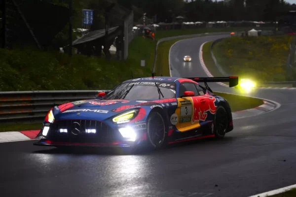 Max Verstappen's Red Bull-liveried #3 Mercedes-AMG GT3 leading the 2026 Nürburgring 24 Hours through the Nordschleife at dawn, before the late driveshaft failure that cost the team victory.