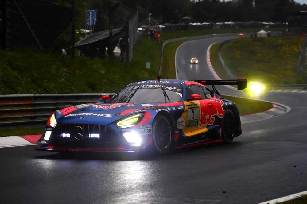 Max Verstappen's Red Bull-liveried #3 Mercedes-AMG GT3 leading the 2026 Nürburgring 24 Hours through the Nordschleife at dawn, before the late driveshaft failure that cost the team victory.