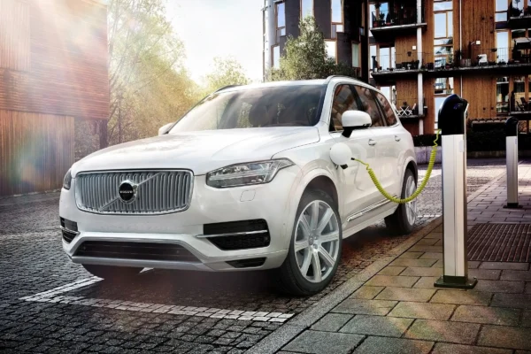 A Volvo XC90 plug-in hybrid SUV photographed alongside a Volvo Trucks heavy goods vehicle, illustrating the contrasting powertrain strategies of the two Volvo companies.