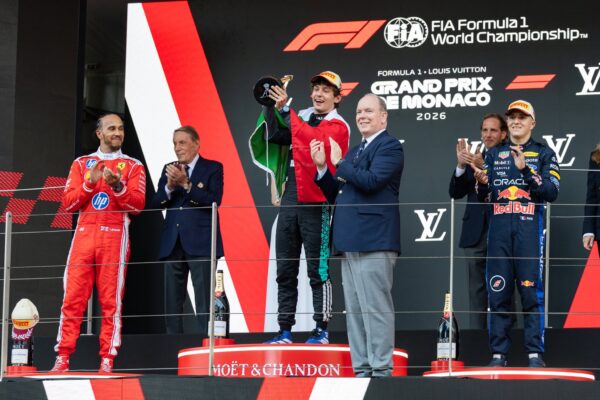 Kimi Antonelli celebrates on the Monaco Grand Prix podium with Lewis Hamilton beside him after becoming the youngest winner of the race in F1 history at 19 years and 9 months.