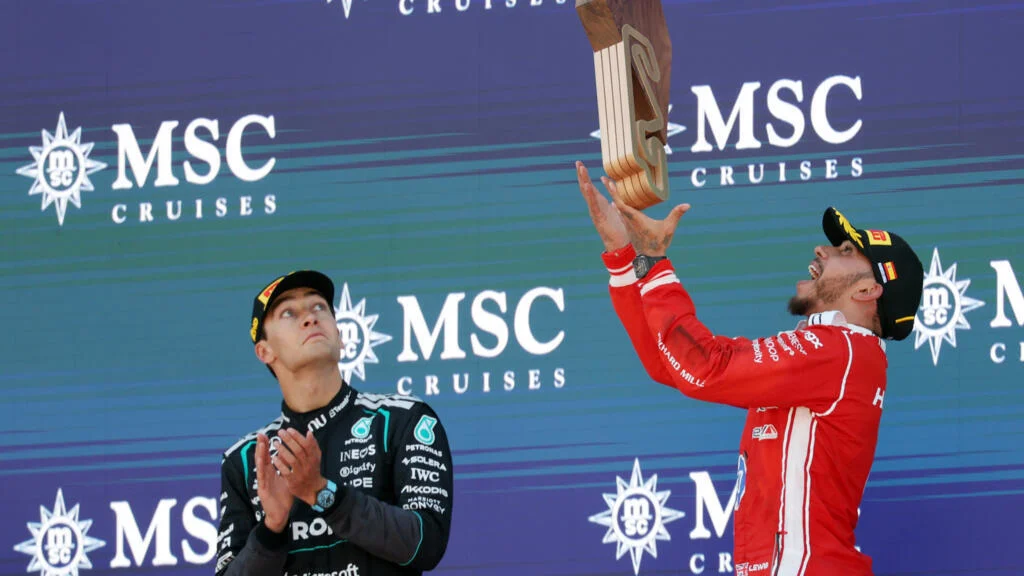 Lewis Hamilton celebrates on the podium with a Ferrari race suit after winning the 2026 Spanish Grand Prix at Barcelona-Catalunya — his first Grand Prix victory for the Italian team.