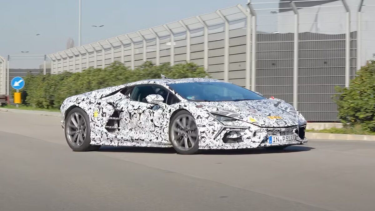A Lamborghini Revuelto SV prototype wrapped in black-and-white swirl camouflage being driven on a public road near the factory in Italy, captured during development testing ahead of its 2026 reveal.