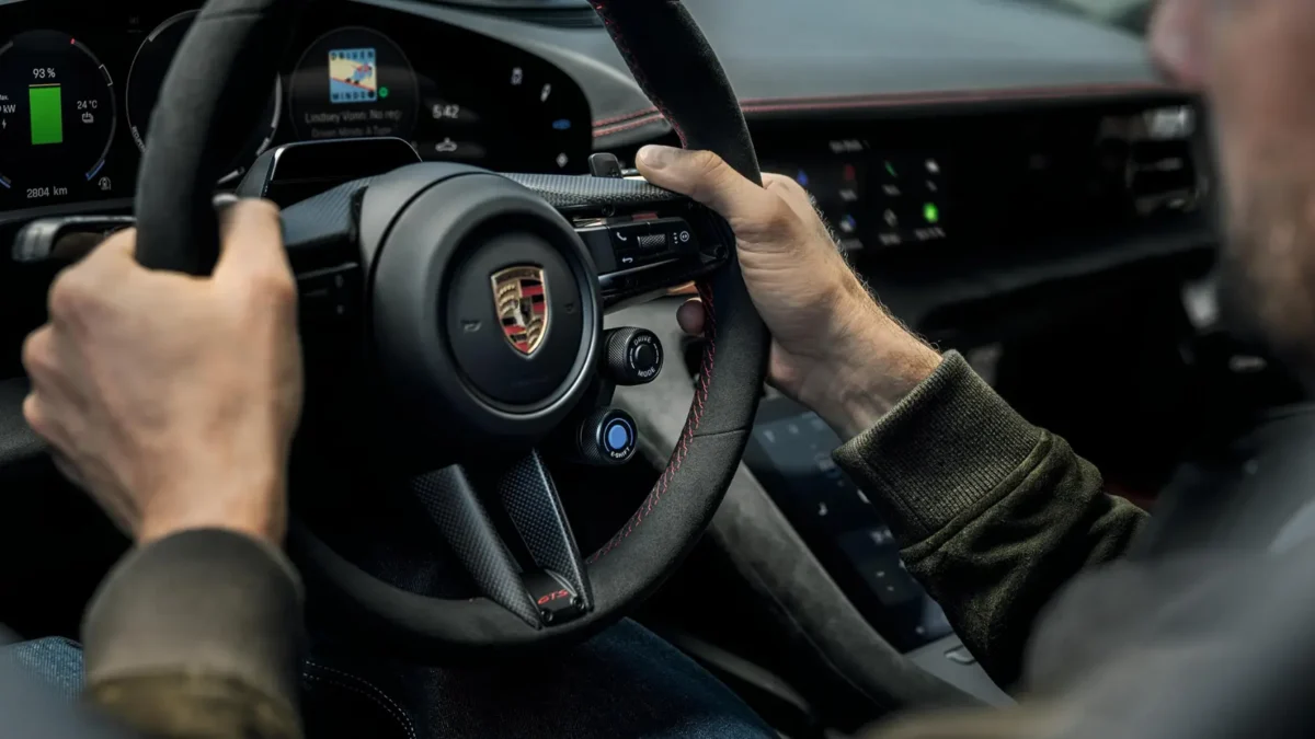 The 2027 Porsche Taycan electric sedan interior showing the GT Sport steering wheel with paddle shifters and virtual rev counter for the new E-Shift simulated eight-speed gearbox system.
