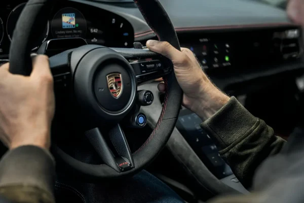 The 2027 Porsche Taycan electric sedan interior showing the GT Sport steering wheel with paddle shifters and virtual rev counter for the new E-Shift simulated eight-speed gearbox system.