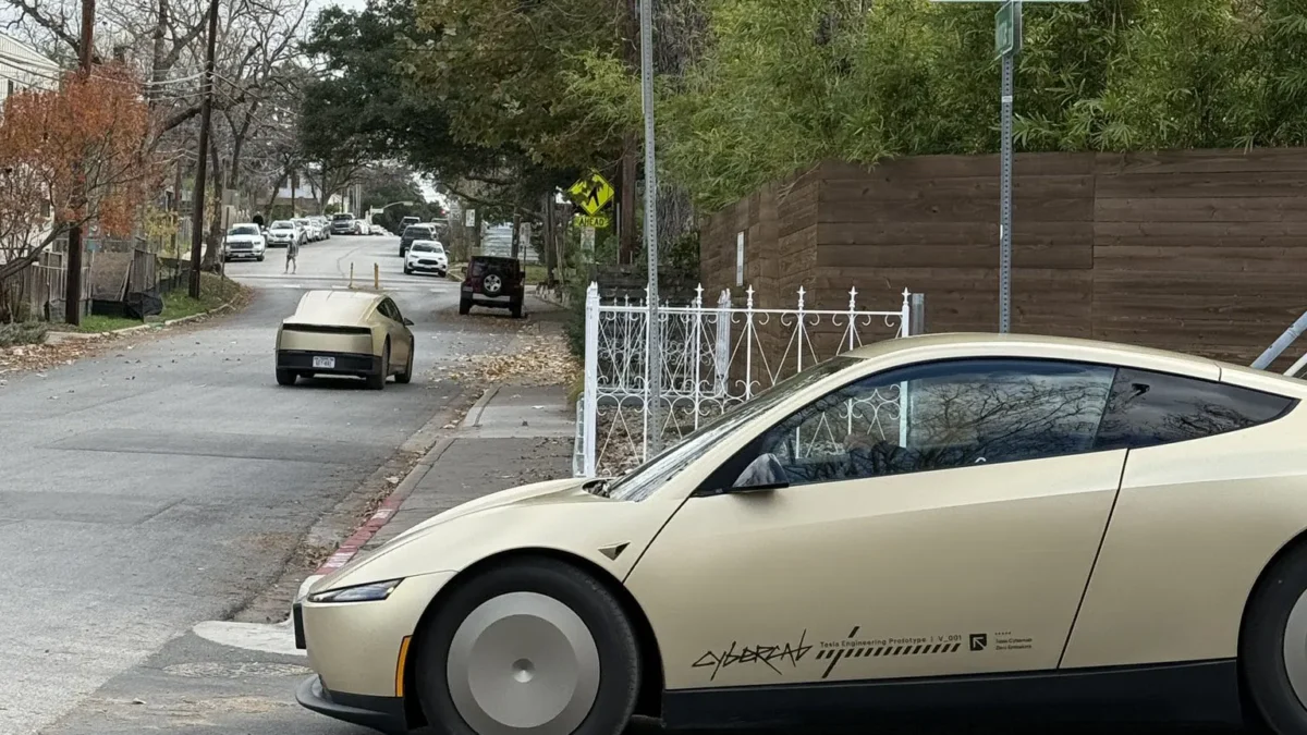A Tesla Cybercab autonomous robotaxi driving without a driver on an Austin Texas street, representing Tesla’s expansion of its unsupervised robotaxi service across the entire Austin metropolitan area in June 2026.