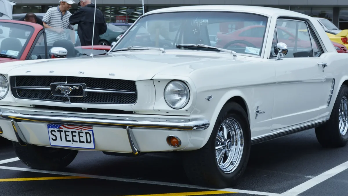 A 1964 Ford Mustang hardtop in Wimbledon White at its World's Fair launch, the car Lee Iacocca convinced Henry Ford II to greenlight in a pivotal 1962 product planning meeting