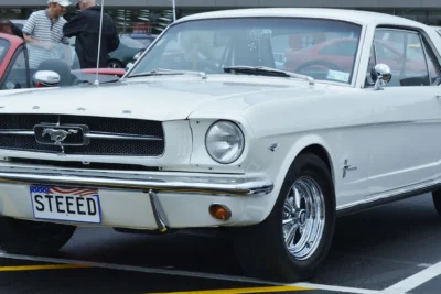 A 1964 Ford Mustang hardtop in Wimbledon White at its World's Fair launch, the car Lee Iacocca convinced Henry Ford II to greenlight in a pivotal 1962 product planning meeting