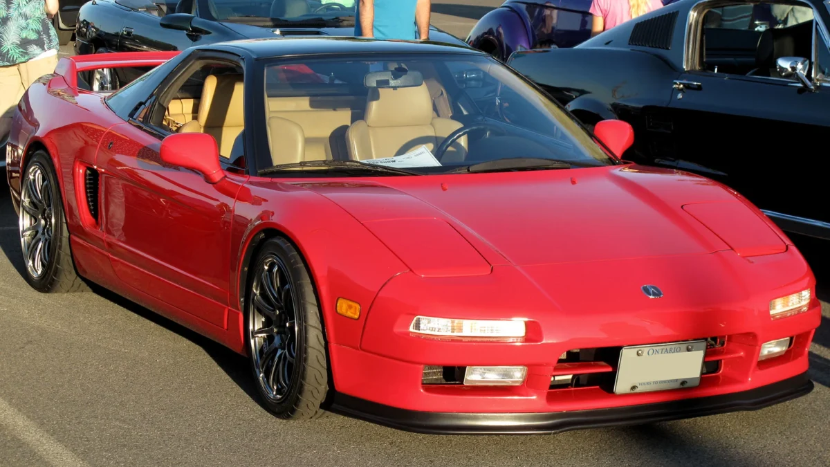 A first-generation Honda NSX NA1 in Formula Red, the supercar whose chassis and suspension were fundamentally revised following test driver feedback from Ayrton Senna at the Suzuka circuit in 1989