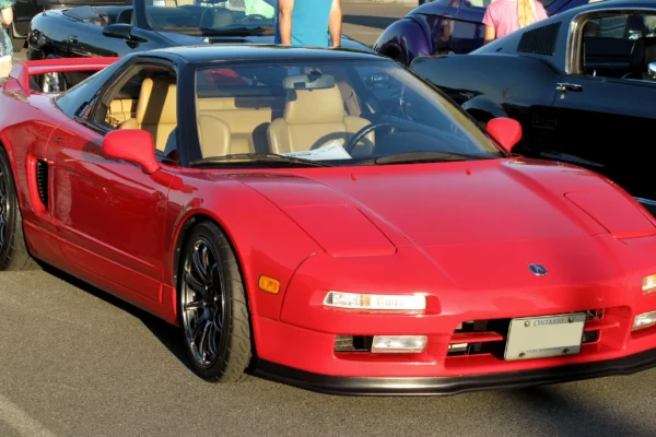 A first-generation Honda NSX NA1 in Formula Red, the supercar whose chassis and suspension were fundamentally revised following test driver feedback from Ayrton Senna at the Suzuka circuit in 1989